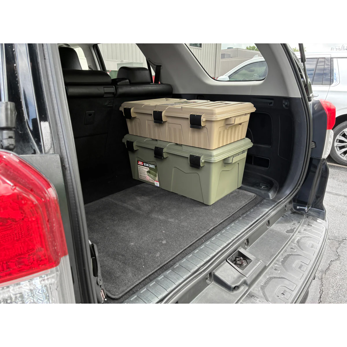 Zwei gestapelte Munitionskisten im Kofferraum eines geparkten Autos.