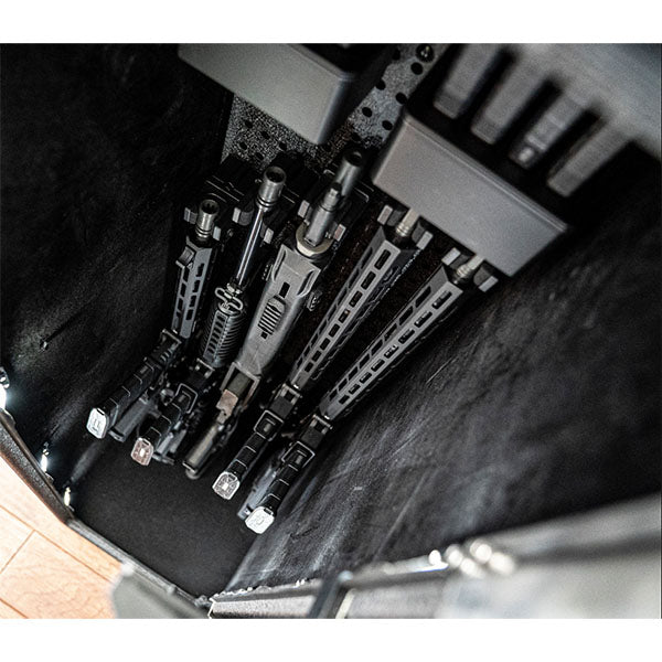 Mehrere Gewehre sind in einem wandmontierten, schmalen Metallgestell senkrecht gelagert.